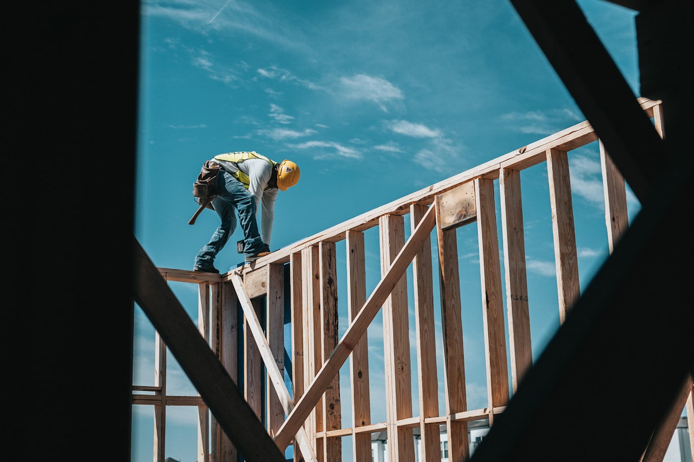 A carpenter working on the timber frame of a house