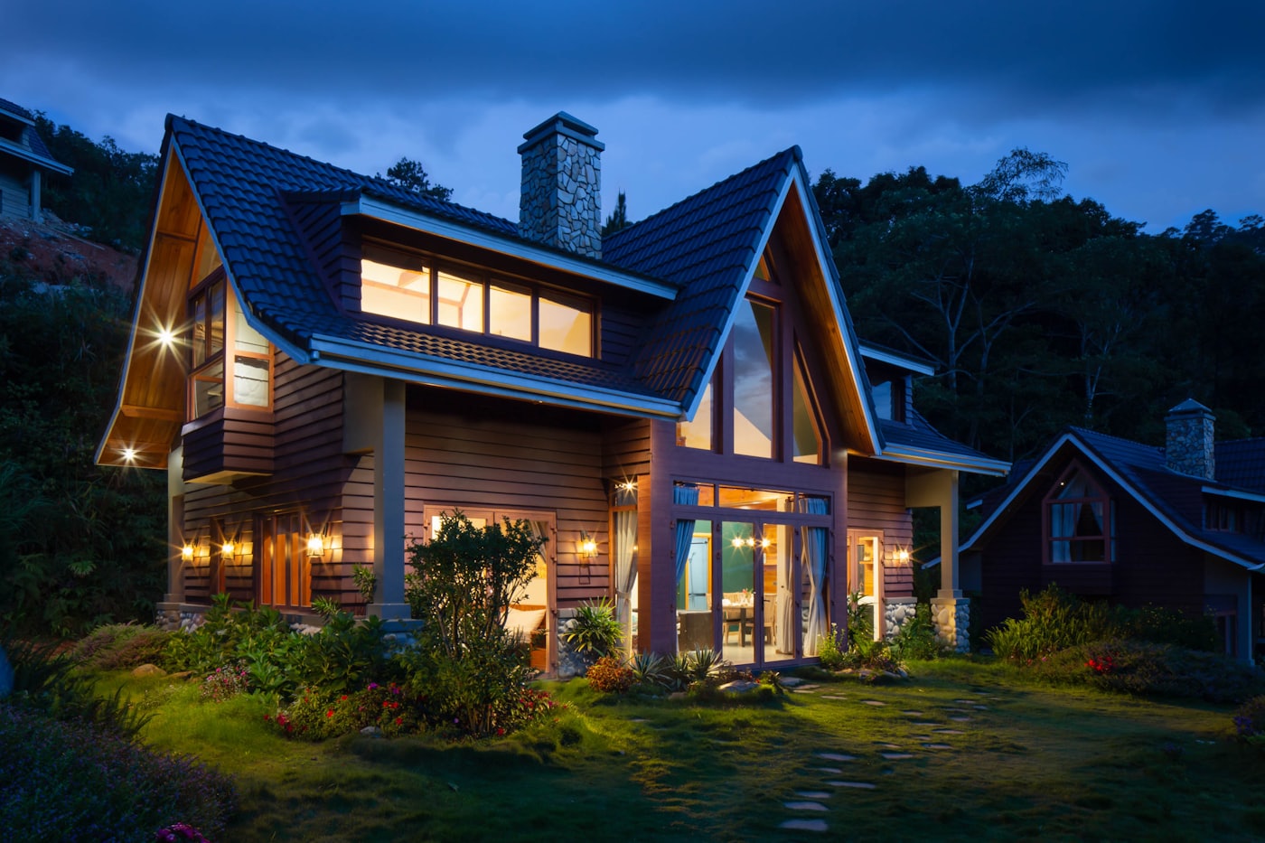 A custom home at dusk with lit windows