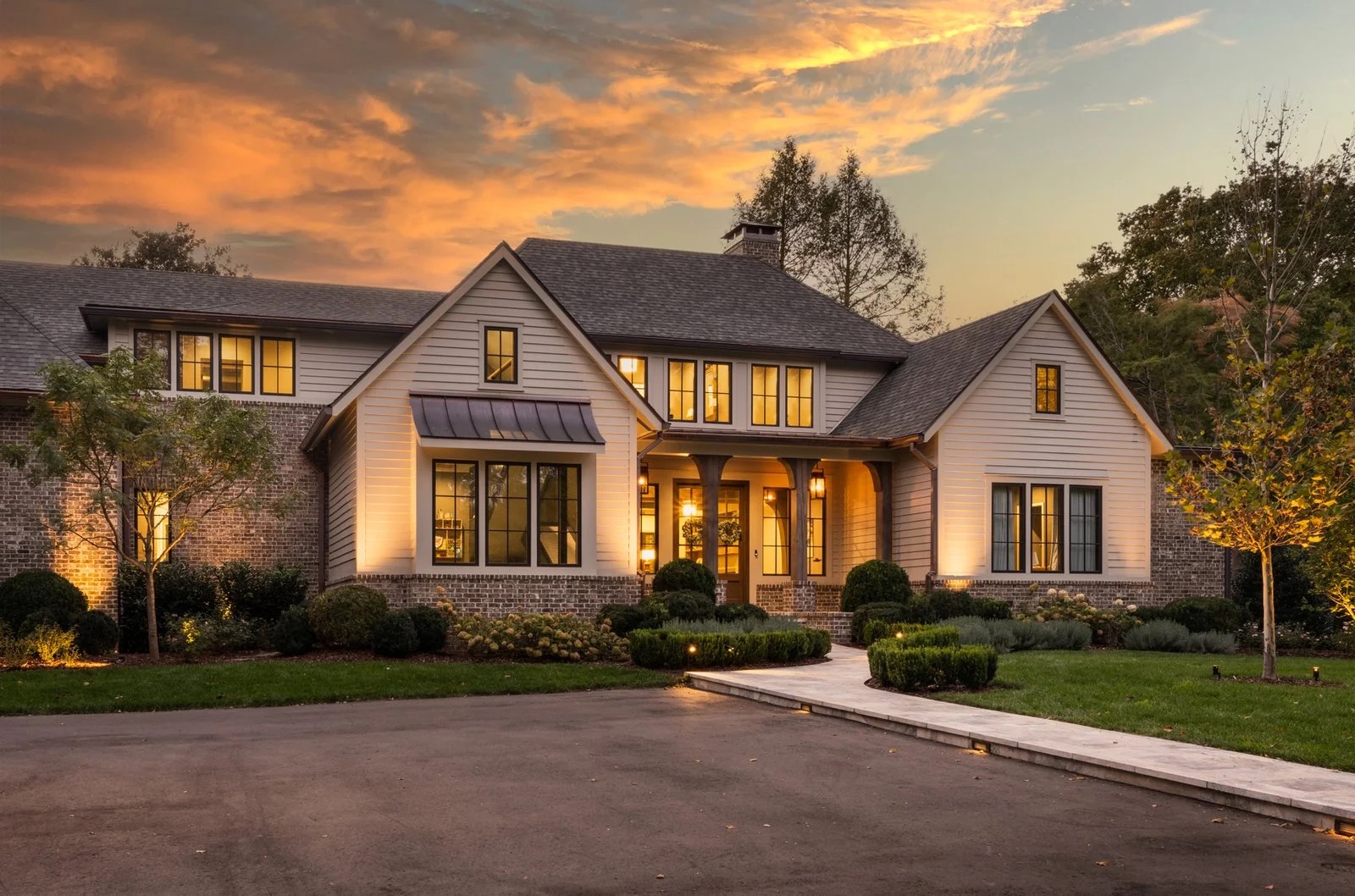 A contemporary home at dusk with warm interior light